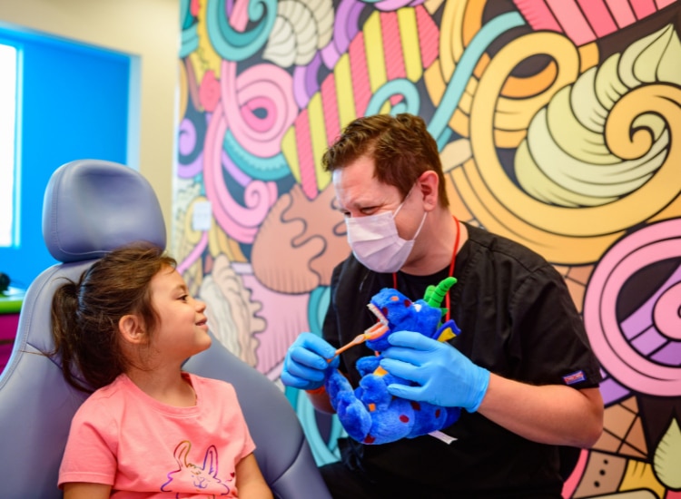 Dentist showing a child how to brush teeth properly